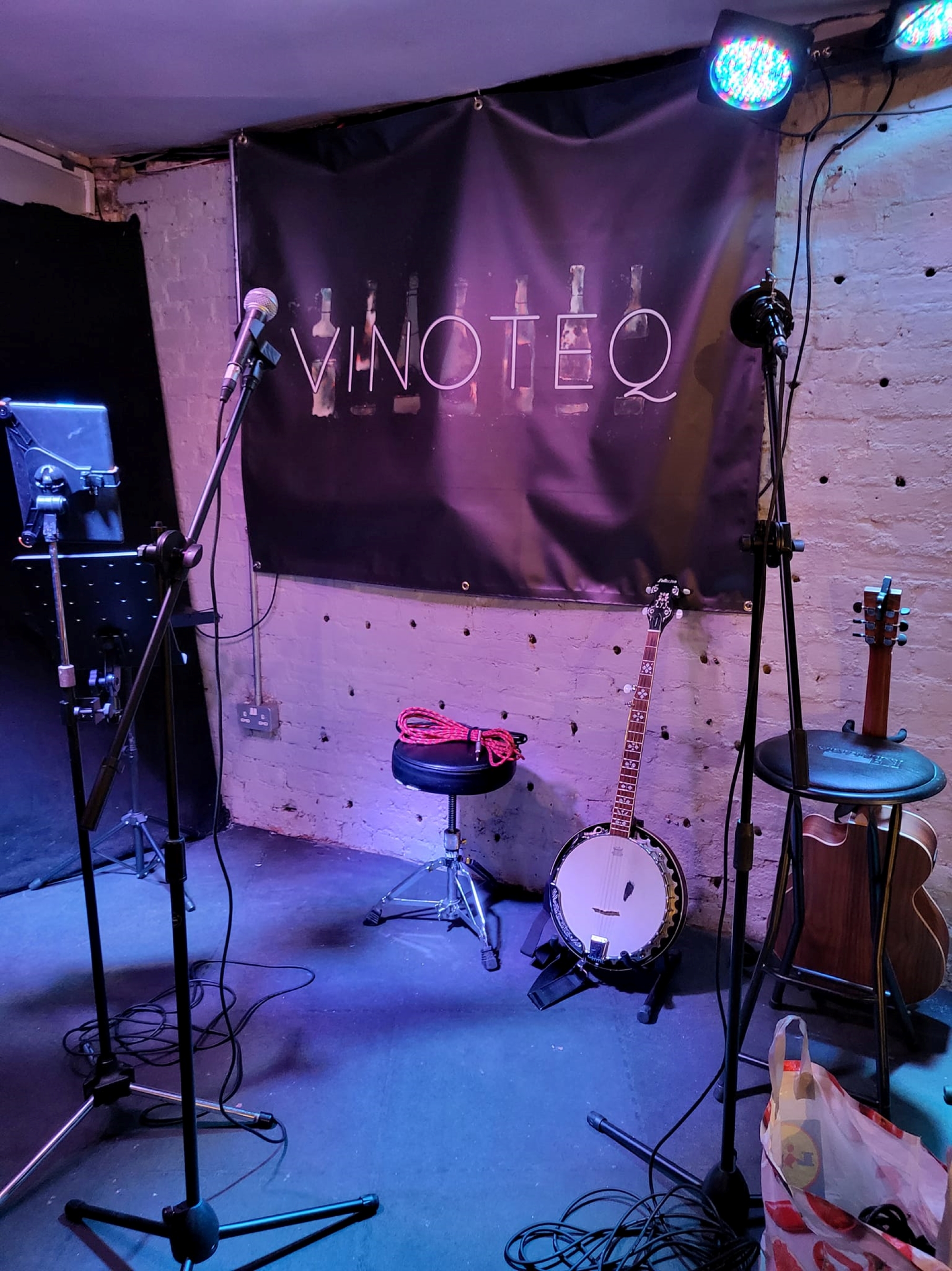 A stage set with microphones on stands and musical instruments