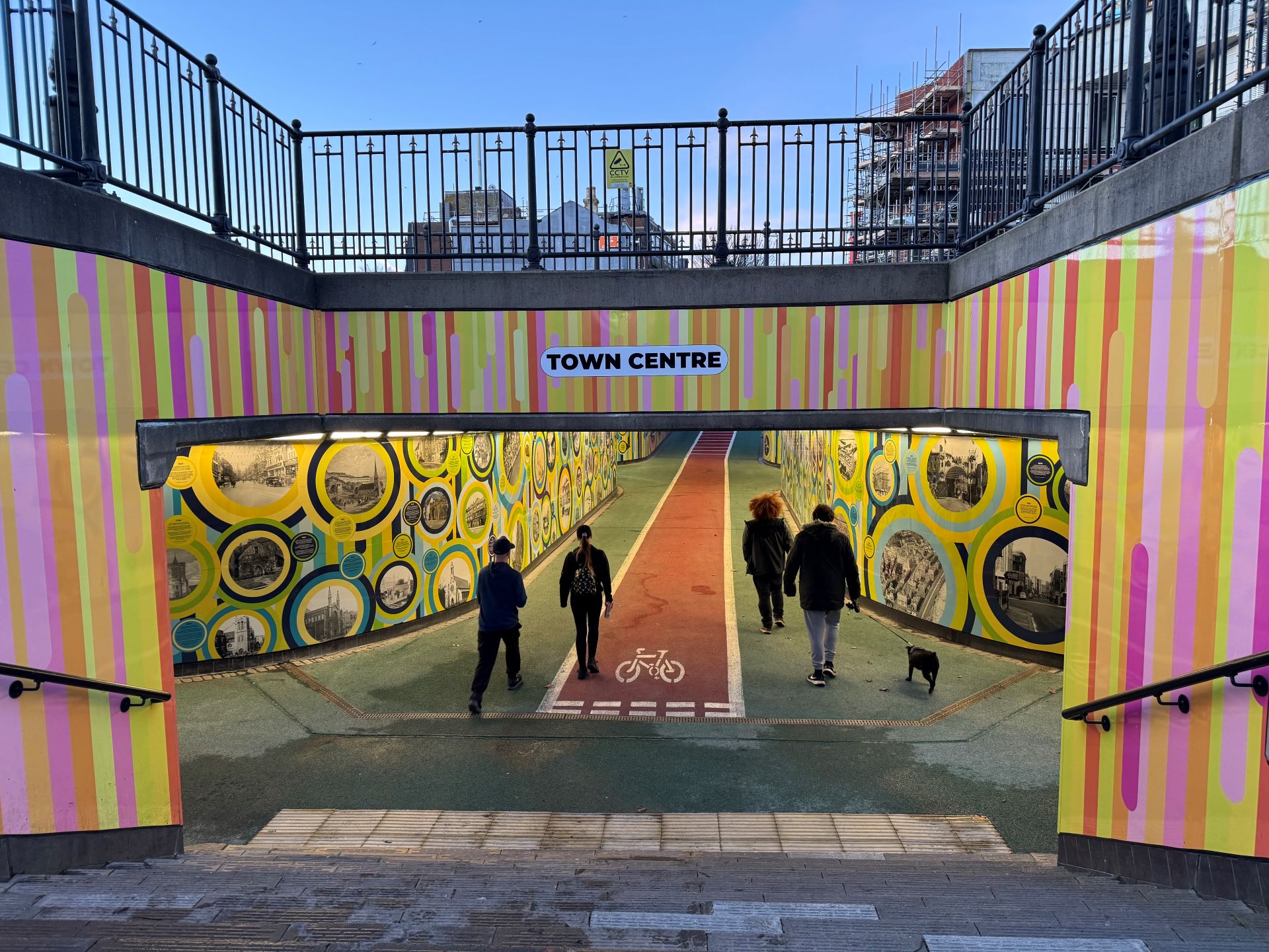 A colourful entrance to a underpass at dusk.