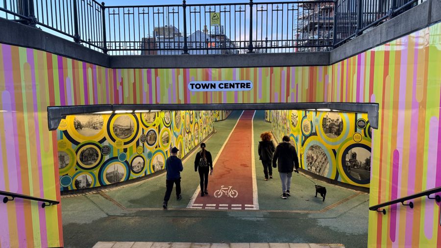 A colourful entrance to a underpass at dusk.