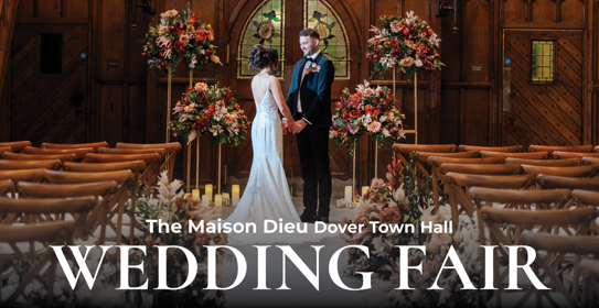 A bride and groom stood in the Maison Dieu's stone hall