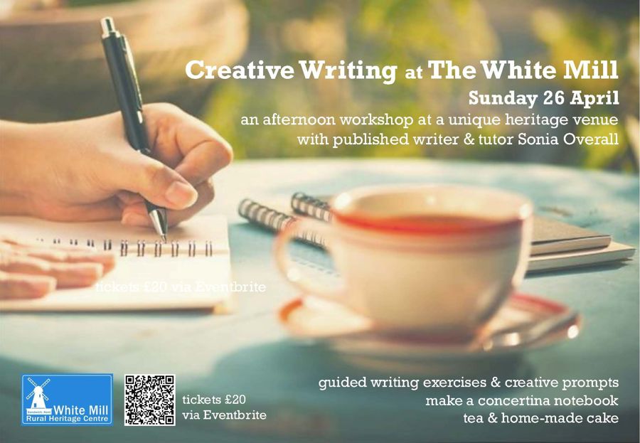 A hand holding a pen writing in an exercise pad, with a cup of tea close by.