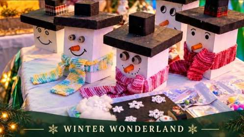 Snowman faces made of wood with black hats and coloured scarfs