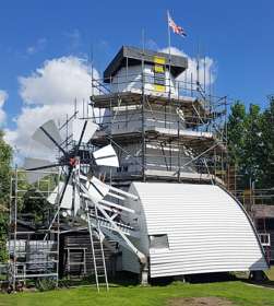 White Mill covered in scaffolding with the cap on the ground during renovations