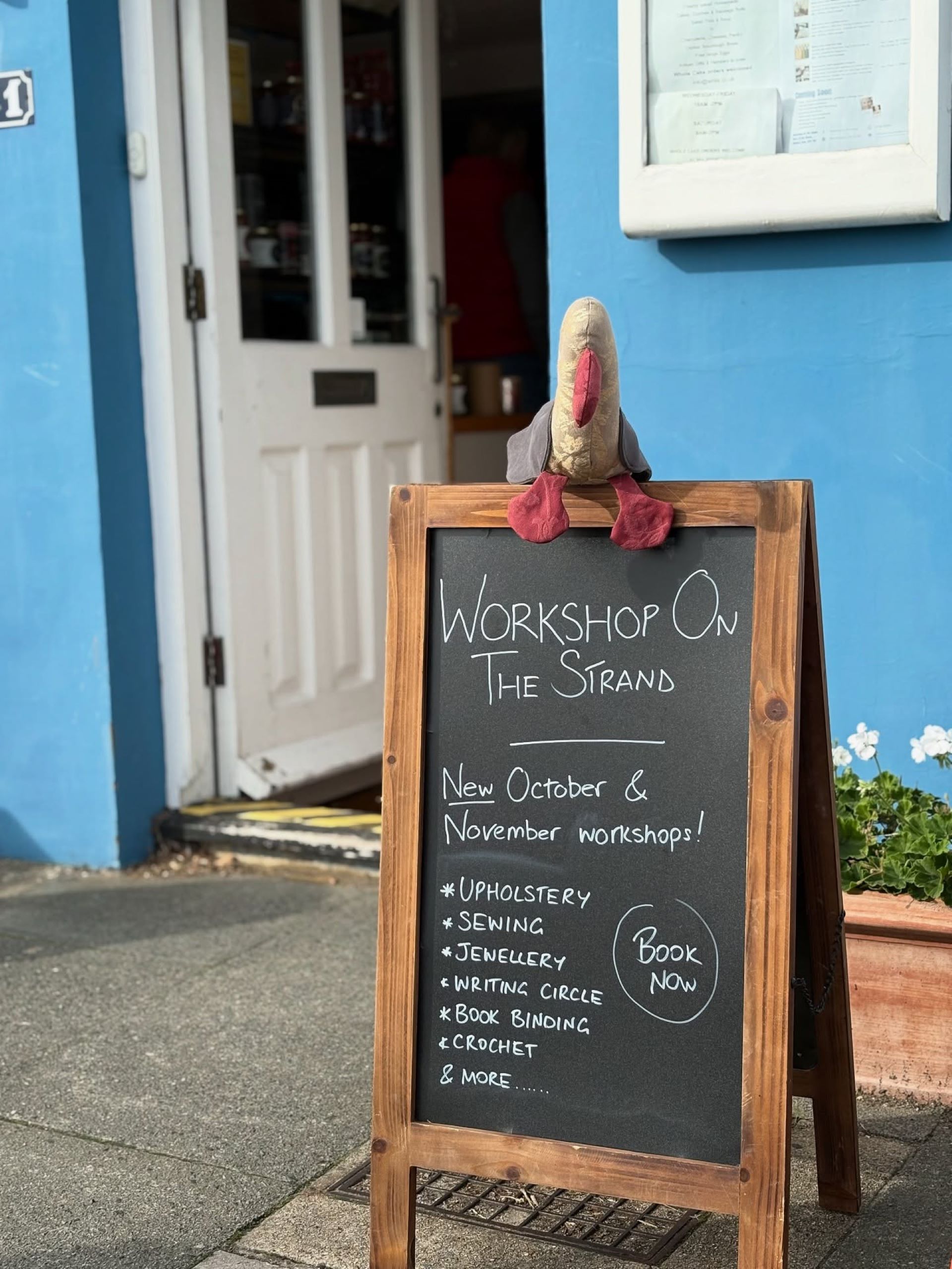 A chalkboard outside a blue painted building