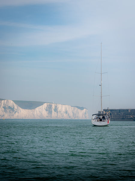 White cliffs in the distance with a yacht in the foreground