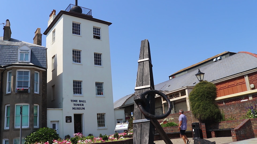 Outside view of Deal Timeball Tower, with flowerbeds and a large anchor outside